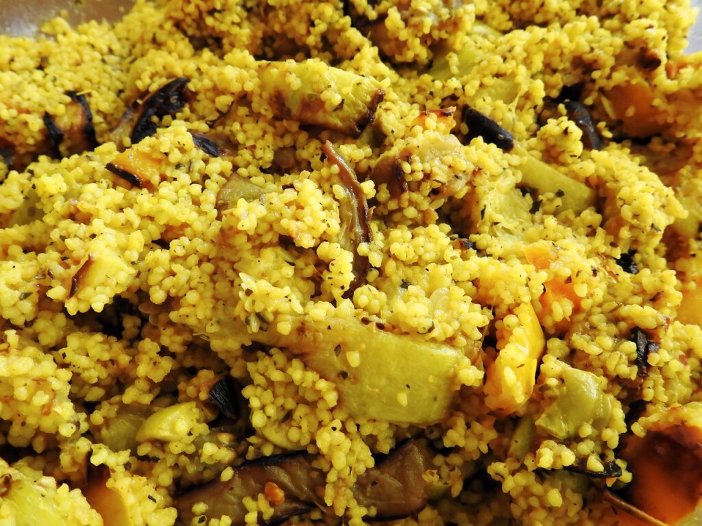 Gelber Couscous mit gebratenem Gemüse wie Zucchini, Aubergine und Paprika.
